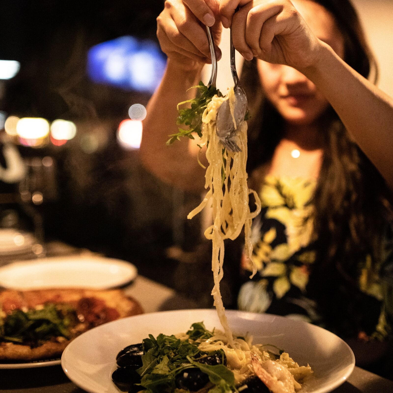 A woman eating handcrafted pasta at il Mercato, one of the best-rated Okanagan Valley Italian Restaurants