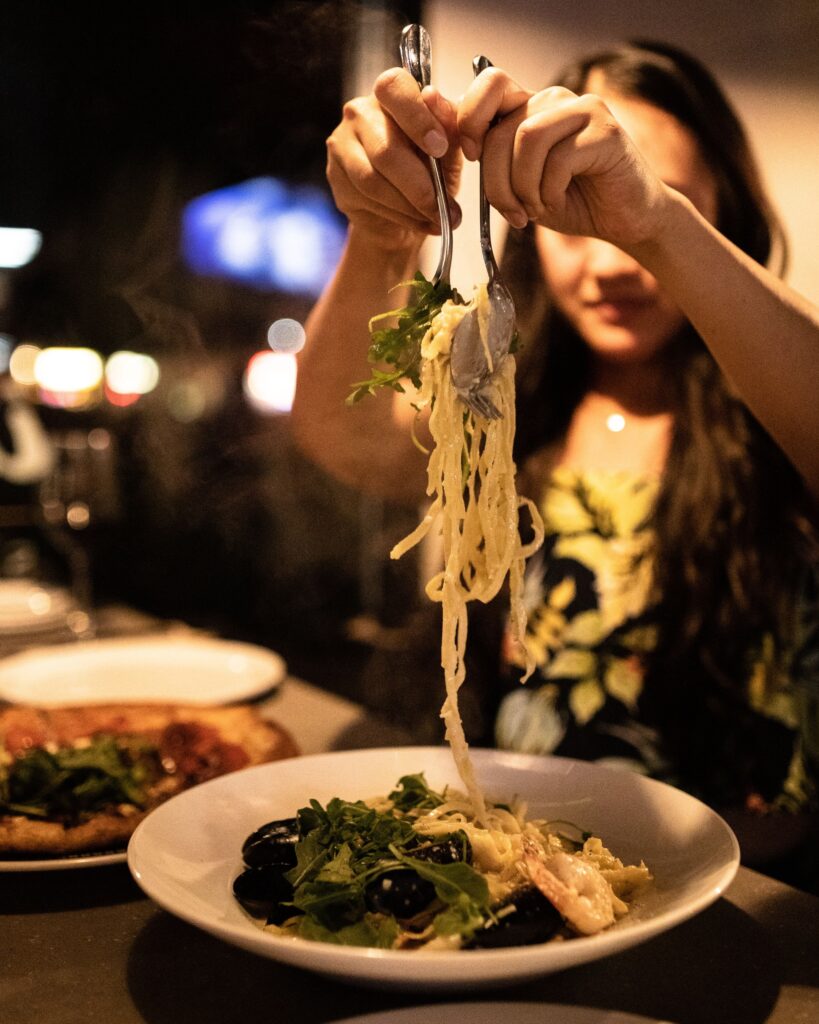 A woman eating handcrafted pasta at il Mercato, one of the best-rated Okanagan Valley Italian Restaurants